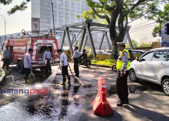 Anggota Polsek Lowokwaru Polresta Malang Kota Sigap Bersihkan Tumpahan Oli